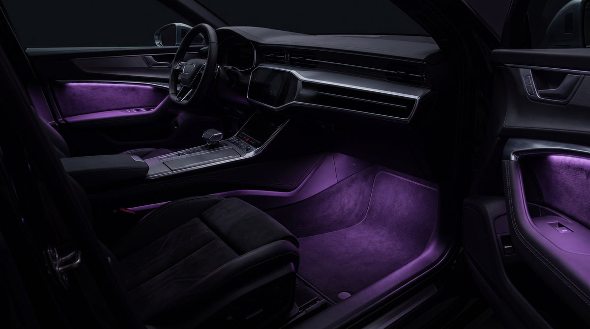 Deep purple ambient light across a dark car interior at night, source hidden