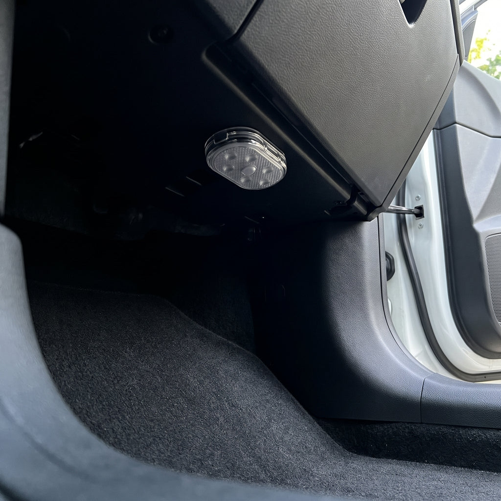 A Stealthglow light mounted deep under the dashboard, tucked back above the footwell of a clean car, switched off